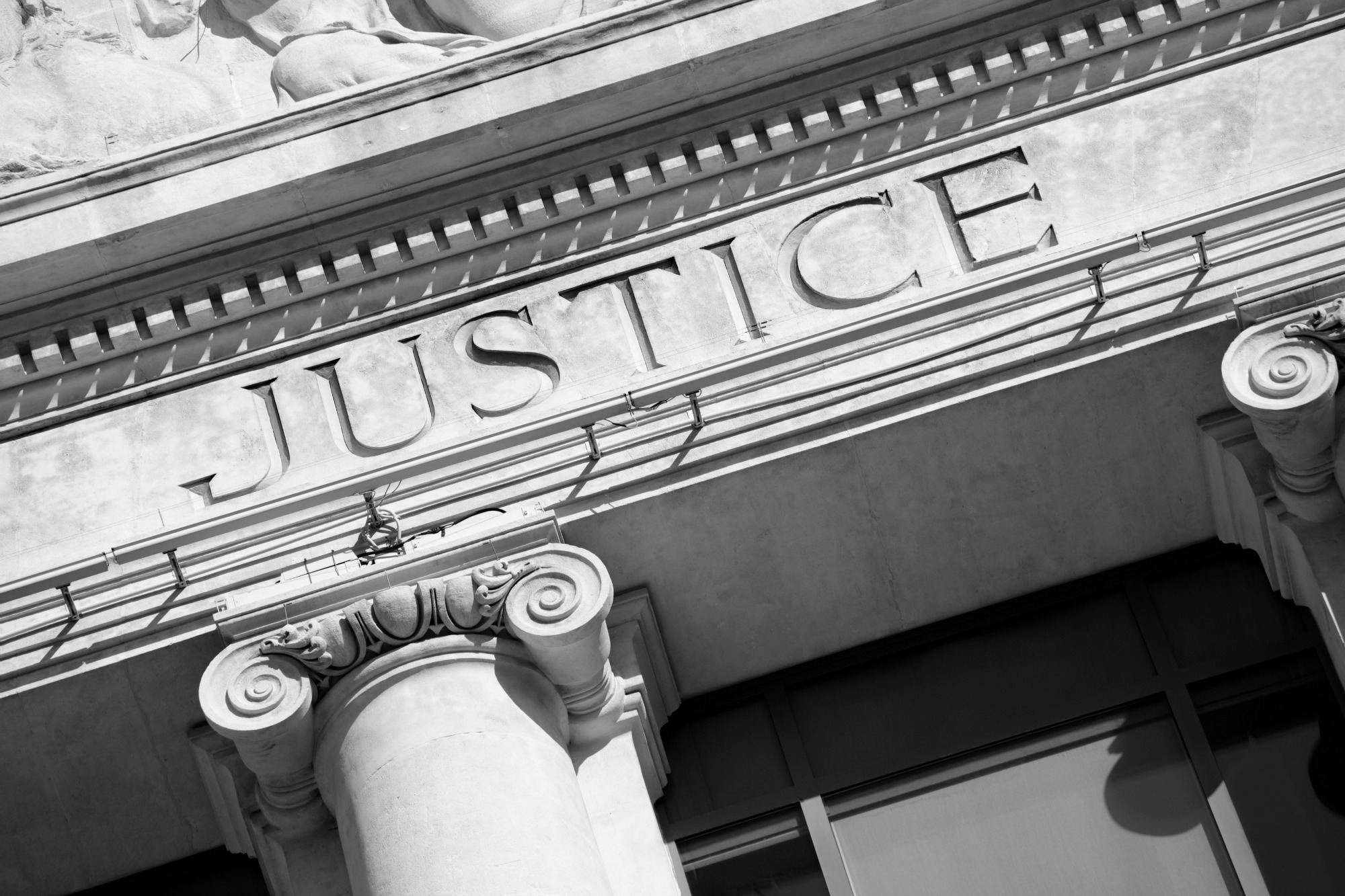 The Word Justice On A Courtroom Building.